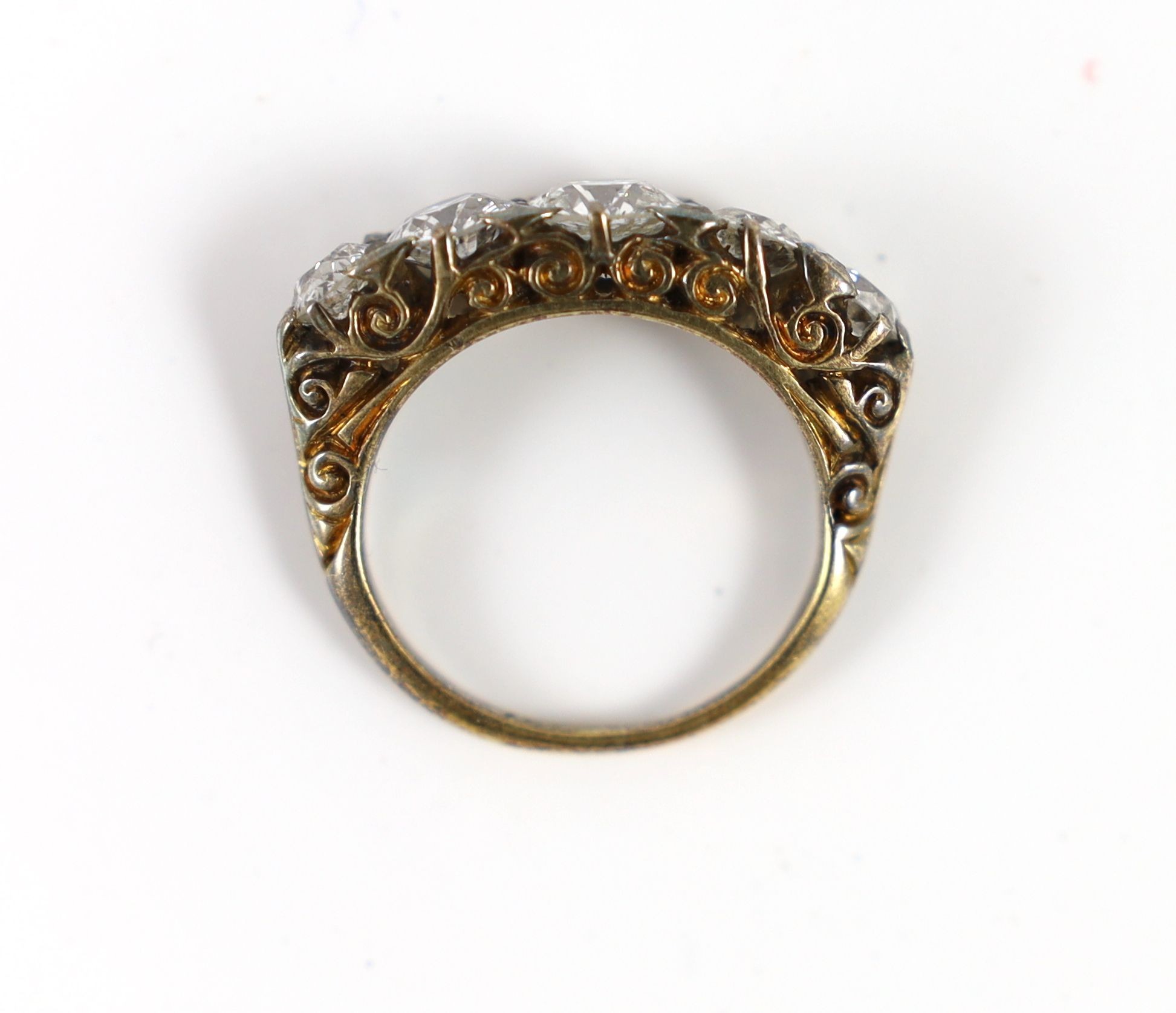 An early 20th century 18ct gold and graduated five stone diamond set half hoop ring